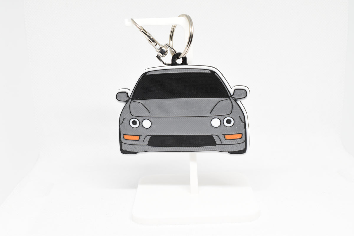 Pocket Motors Acura Integra Dc2 keychain displayed on a white stand with metal ring and clip.