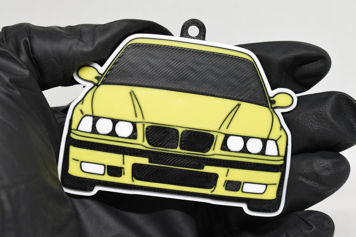 3D printed yellow BMW M3 E36 keychain held in hand, front view detail by LayerPlay Pocket Motors