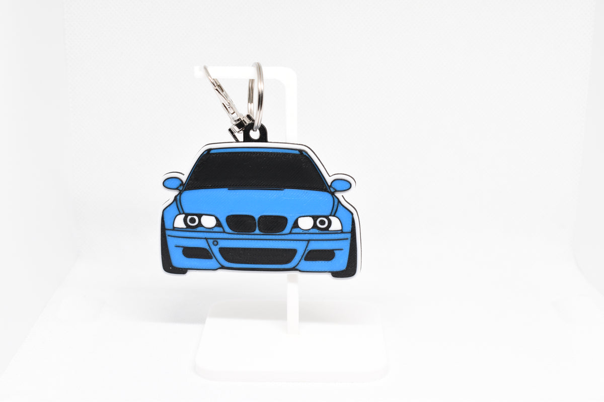 Pocket Motors BMW M3 E46 keychain displayed on a white stand with metal ring and clip.