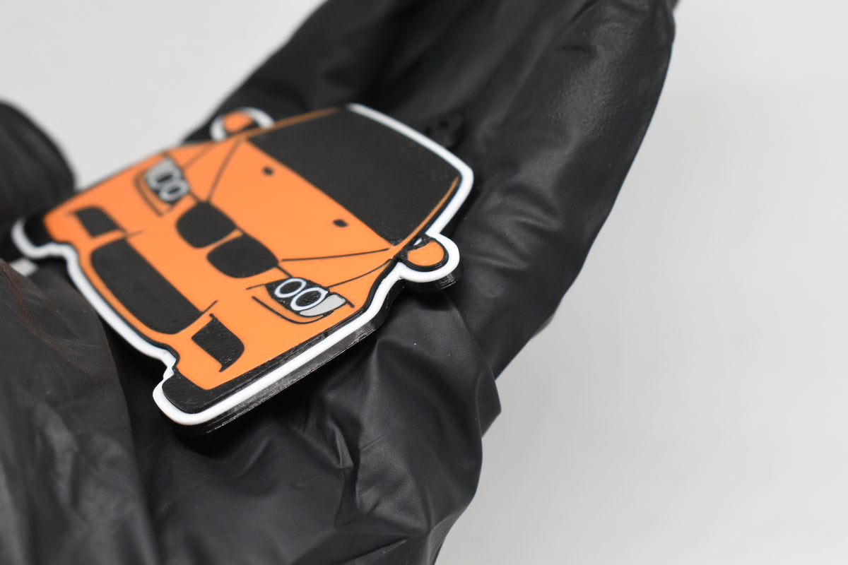 Side angle view showing 3D layered detail of orange BMW M3 E92 keychain by LayerPlay Pocket Motors