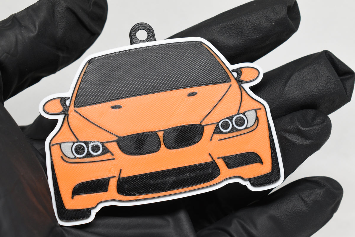 3D printed orange BMW M3 E92 keychain held in hand, front view detail by LayerPlay Pocket Motors