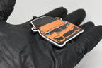 Side angle view showing 3D layered detail of orange BMW M3 F80 keychain by LayerPlay Pocket Motors