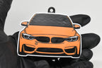 3D printed orange BMW M3 F80 keychain held in hand, front view detail by LayerPlay Pocket Motors