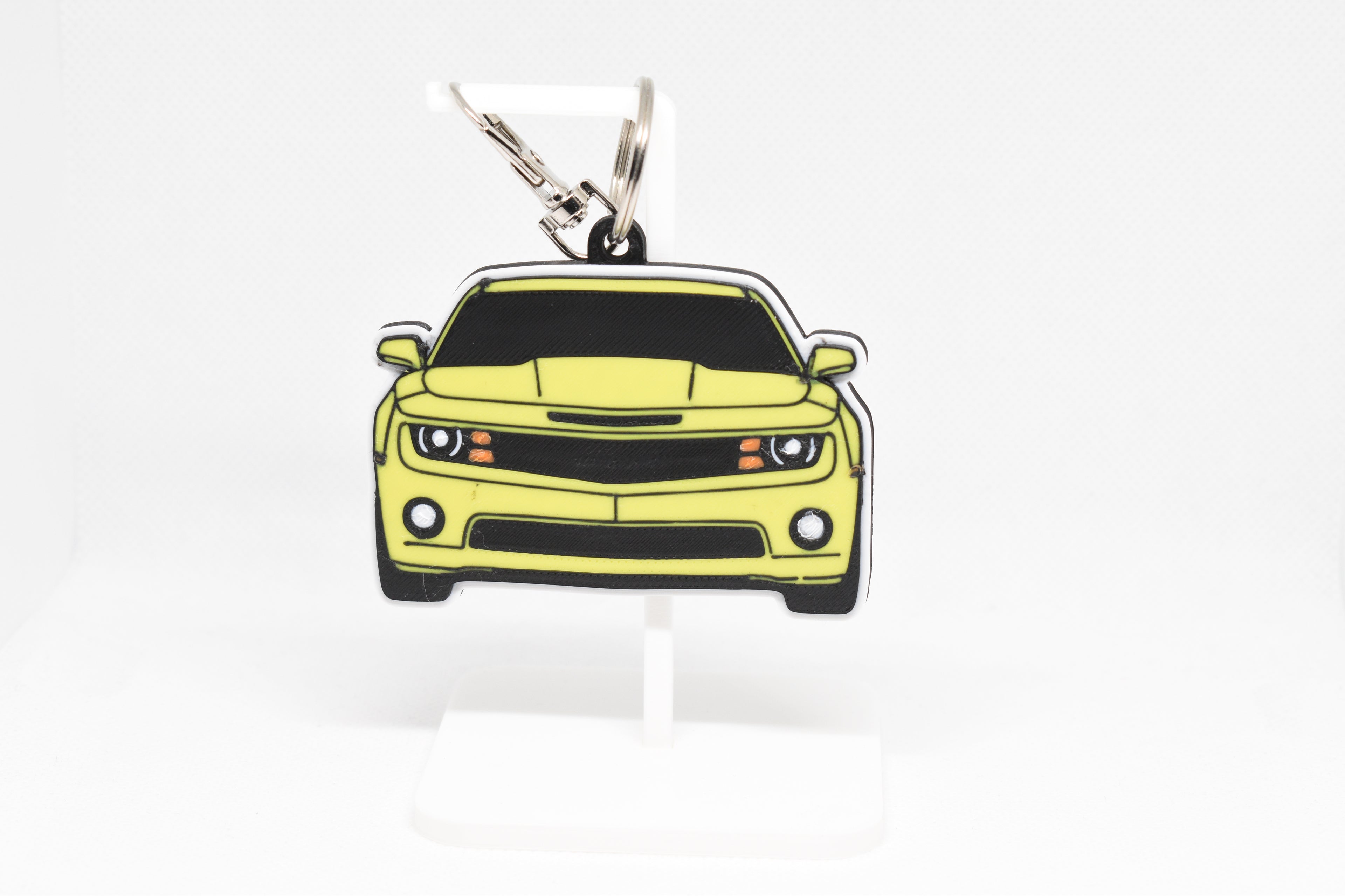 Pocket Motors Camaro SS 5th Gen keychain displayed on a white stand with metal ring and clip.