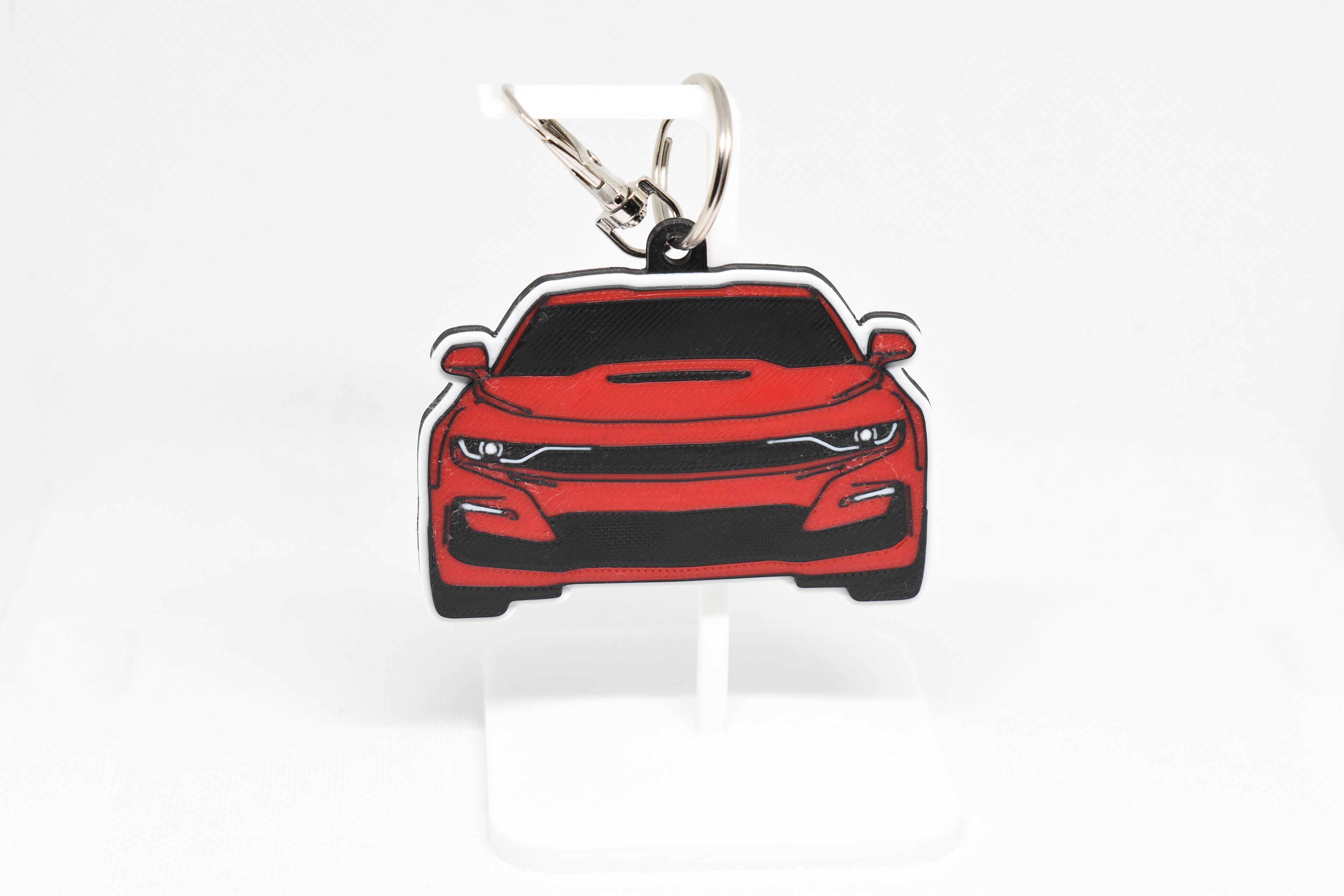 Pocket Motors Camaro SS 6th Gen facelift keychain displayed on a white stand with metal ring and clip.