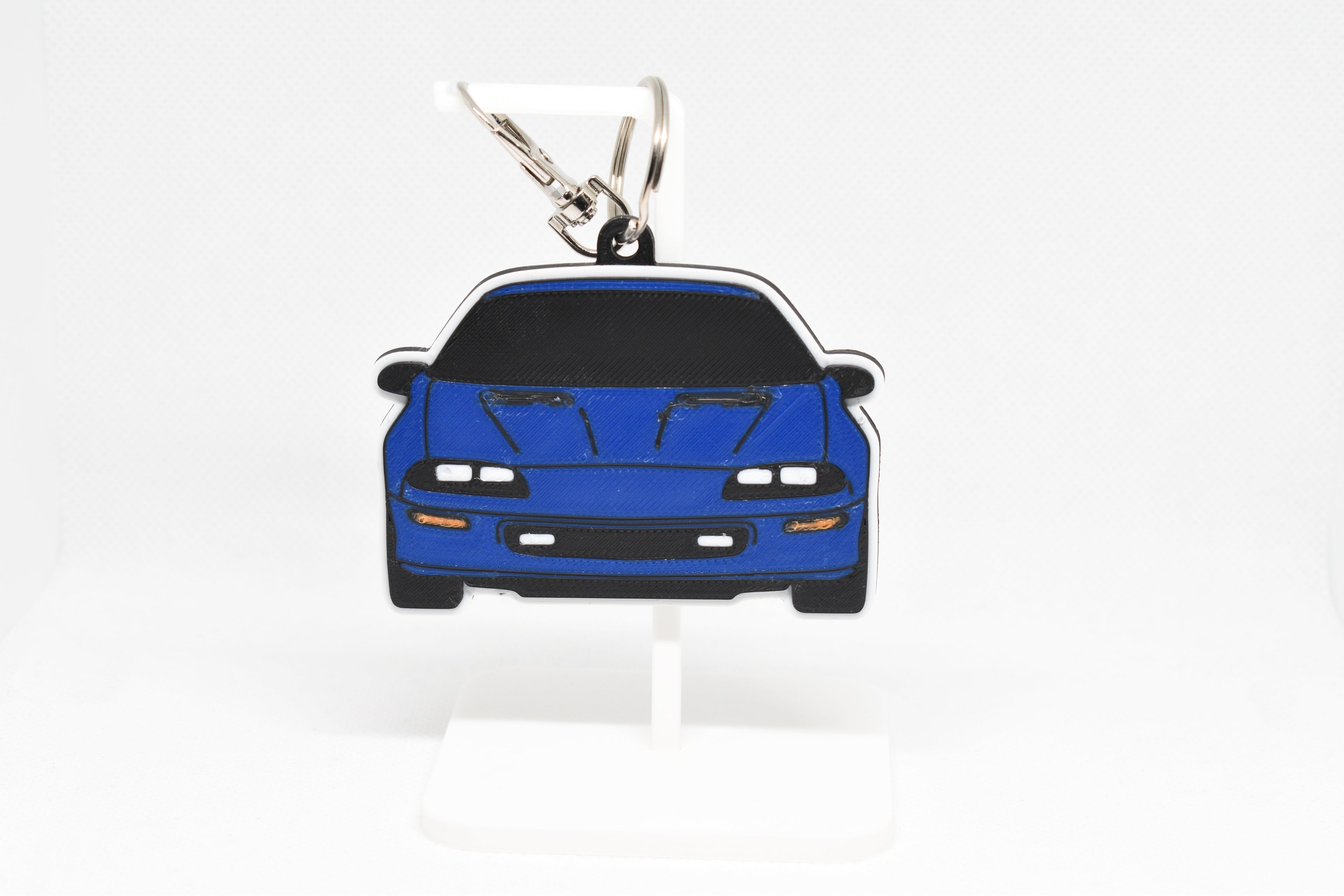 Pocket Motors Camaro Z28 4th Gen keychain displayed on a white stand with metal ring and clip.