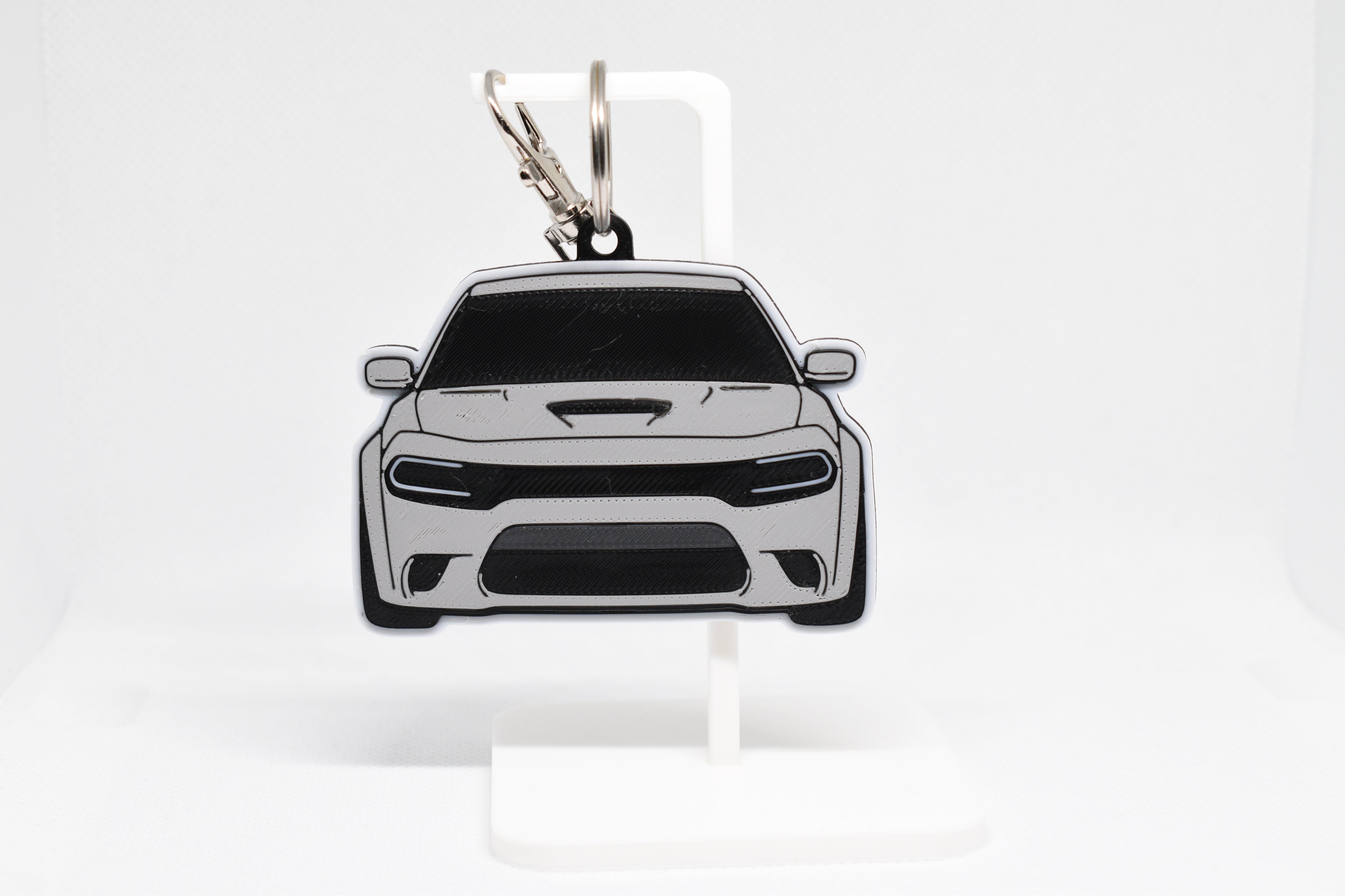 Pocket Motors Charger Hellcat keychain displayed on a white stand with metal ring and clip.