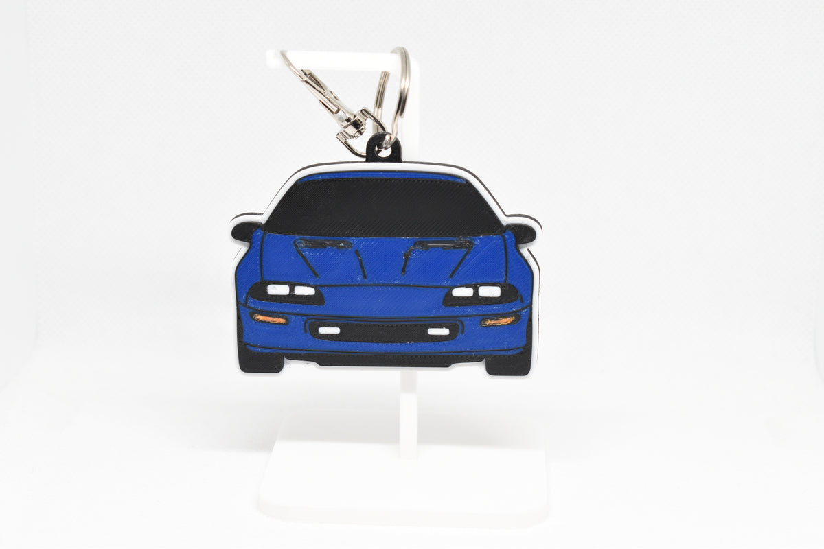 Pocket Motors Chevrolet Camaro Z28 4th Gen keychain displayed on a white stand with metal ring and clip.