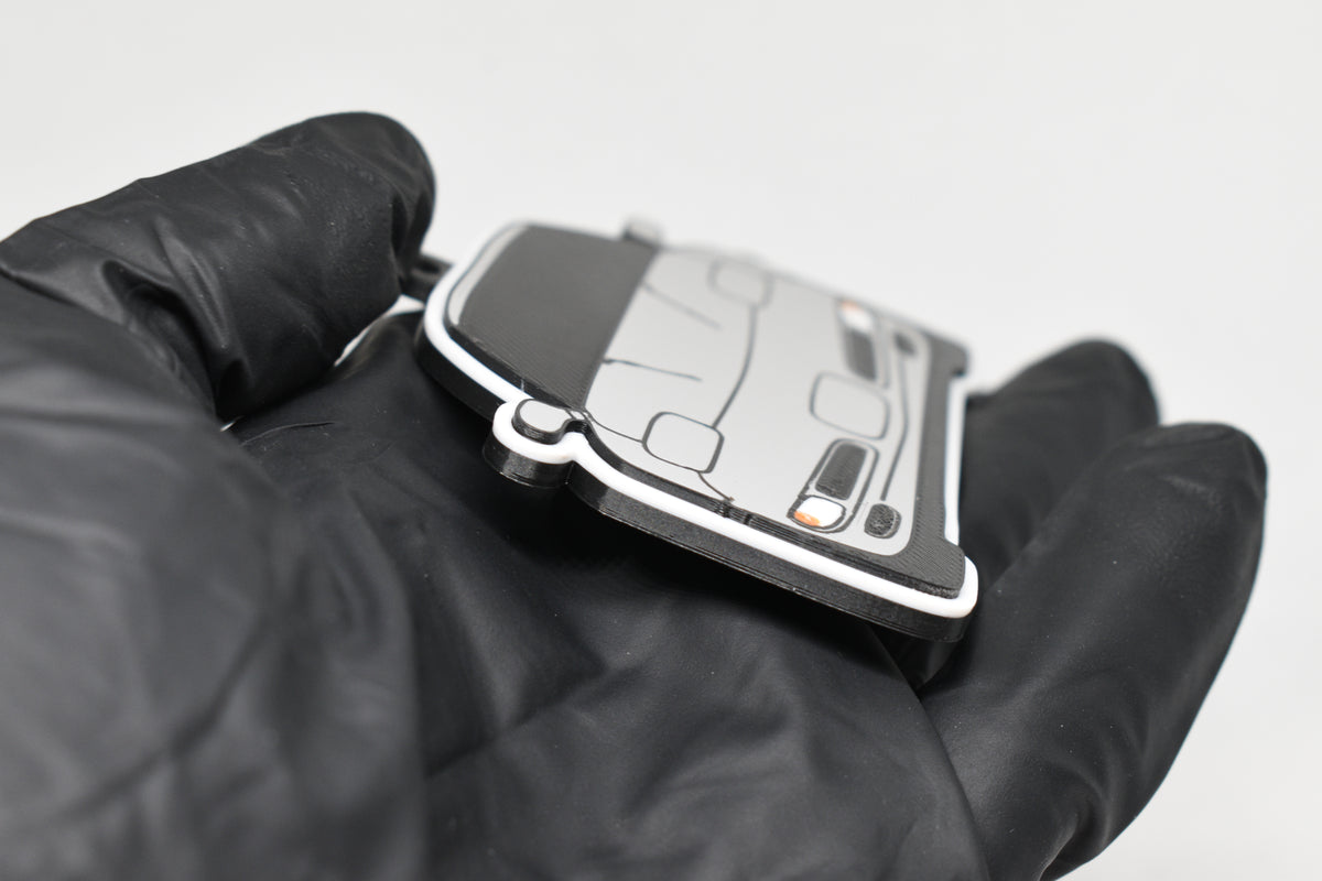 Side angle view showing 3D layered detail of light gray Chevrolet Corvette C5 keychain by LayerPlay Pocket Motors