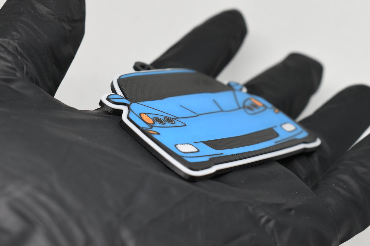 Side angle view showing 3D layered detail of light blue Chevrolet Corvette C6 keychain by LayerPlay Pocket Motors