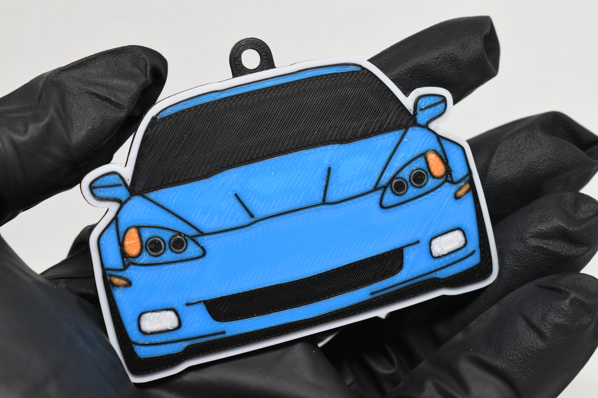 3D printed light blue Chevrolet Corvette C6 keychain held in hand, front view detail by LayerPlay Pocket Motors