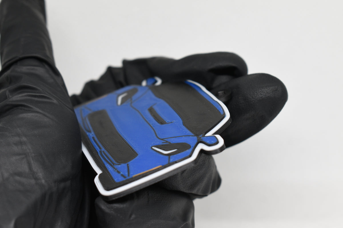 Side angle view showing 3D layered detail of blue Chevrolet Corvette C7 keychain by LayerPlay Pocket Motors