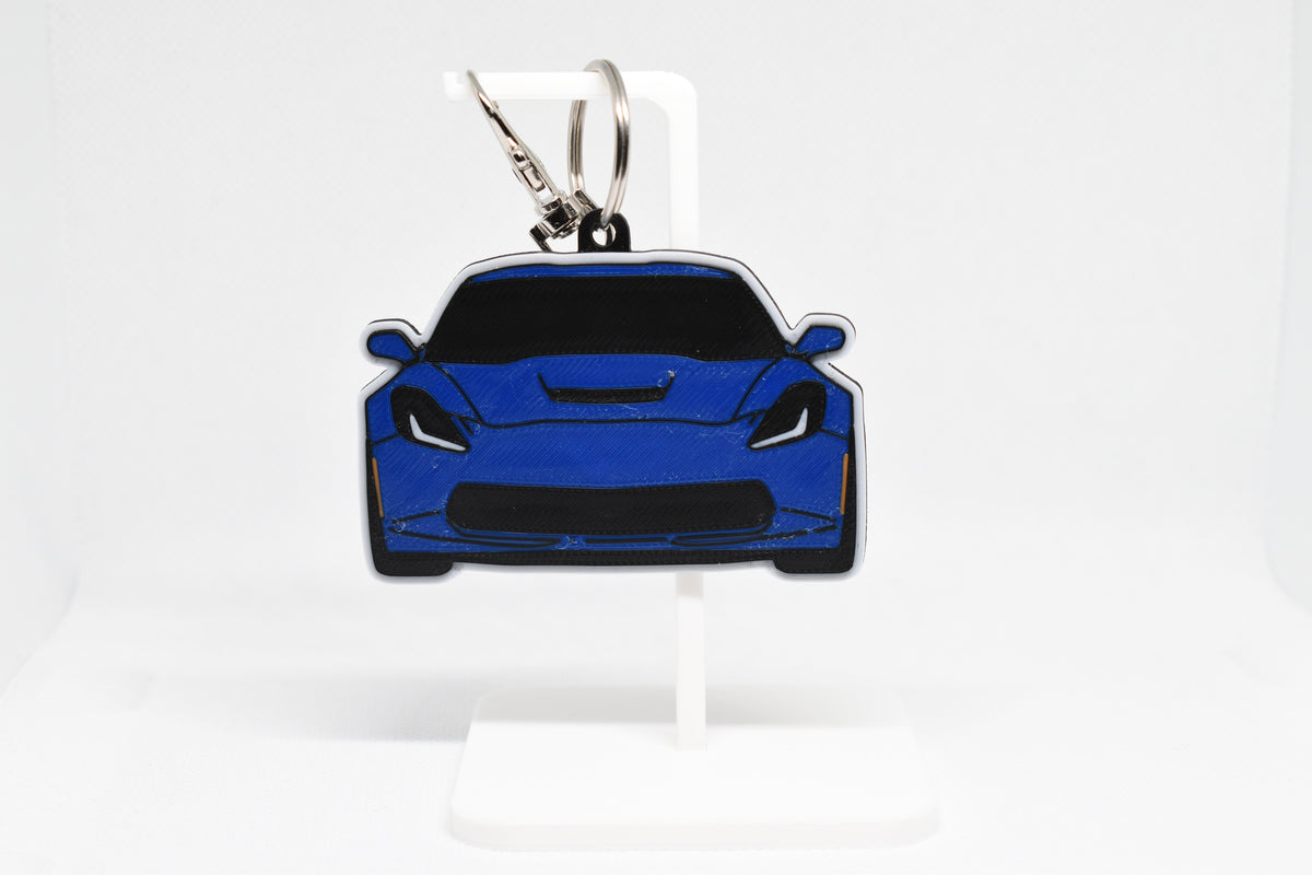 Pocket Motors Chevrolet Corvette C7 keychain displayed on a white stand with metal ring and clip.
