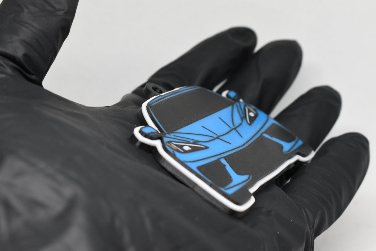 Side angle view showing 3D layered detail of light blue Chevrolet Corvette C8 keychain by LayerPlay Pocket Motors