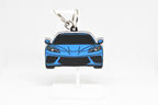 Pocket Motors Corvette C8 keychain displayed on a white stand with metal ring and clip.