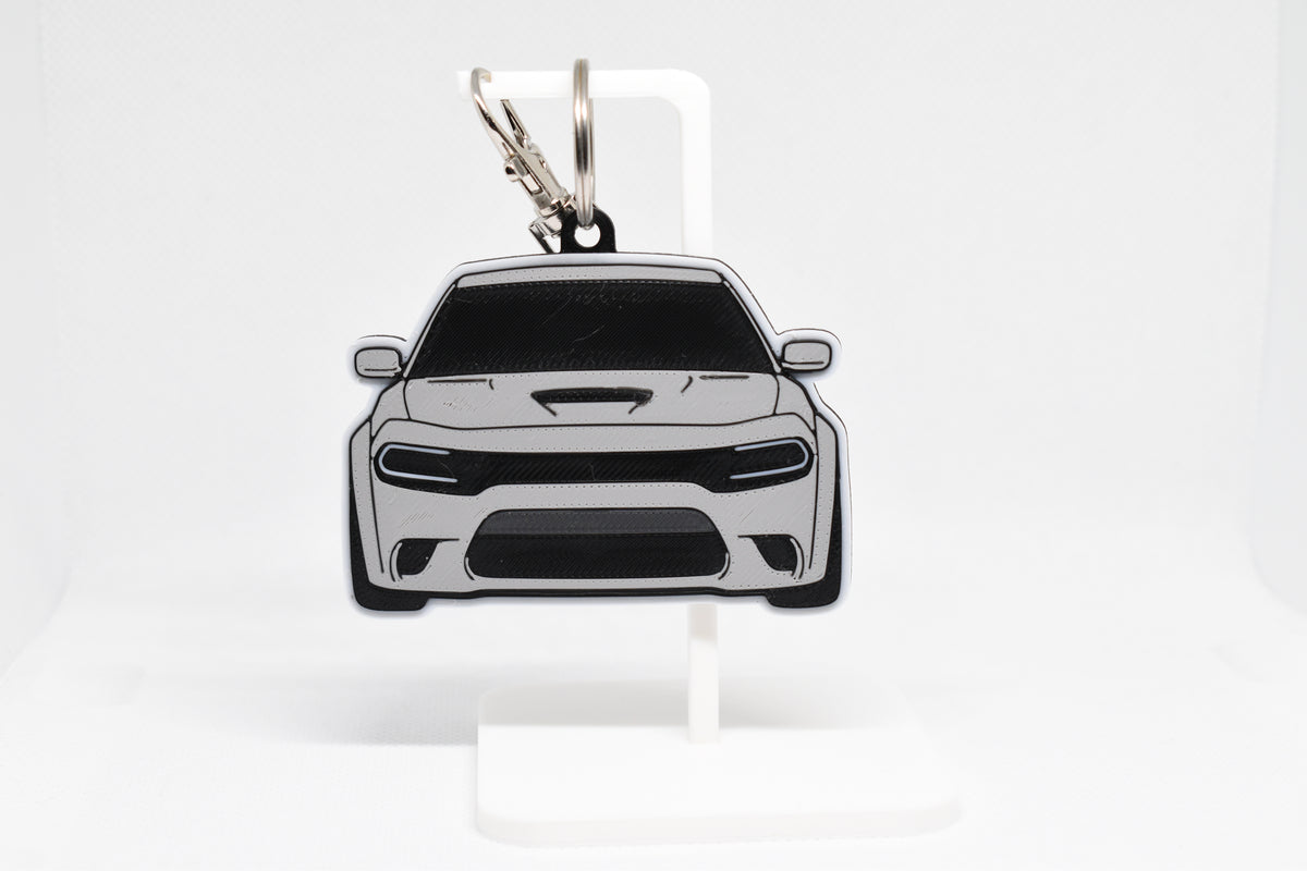 Pocket Motors Dodge Charger Hellcat keychain displayed on a white stand with metal ring and clip.