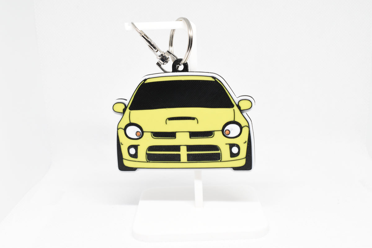 Pocket Motors Dodge Neon SRT‑4 keychain displayed on a white stand with metal ring and clip.