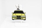 Pocket Motors E36 M3 keychain displayed on a white stand with metal ring and clip.