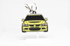 Pocket Motors Evo 8 keychain displayed on a white stand with metal ring and clip.