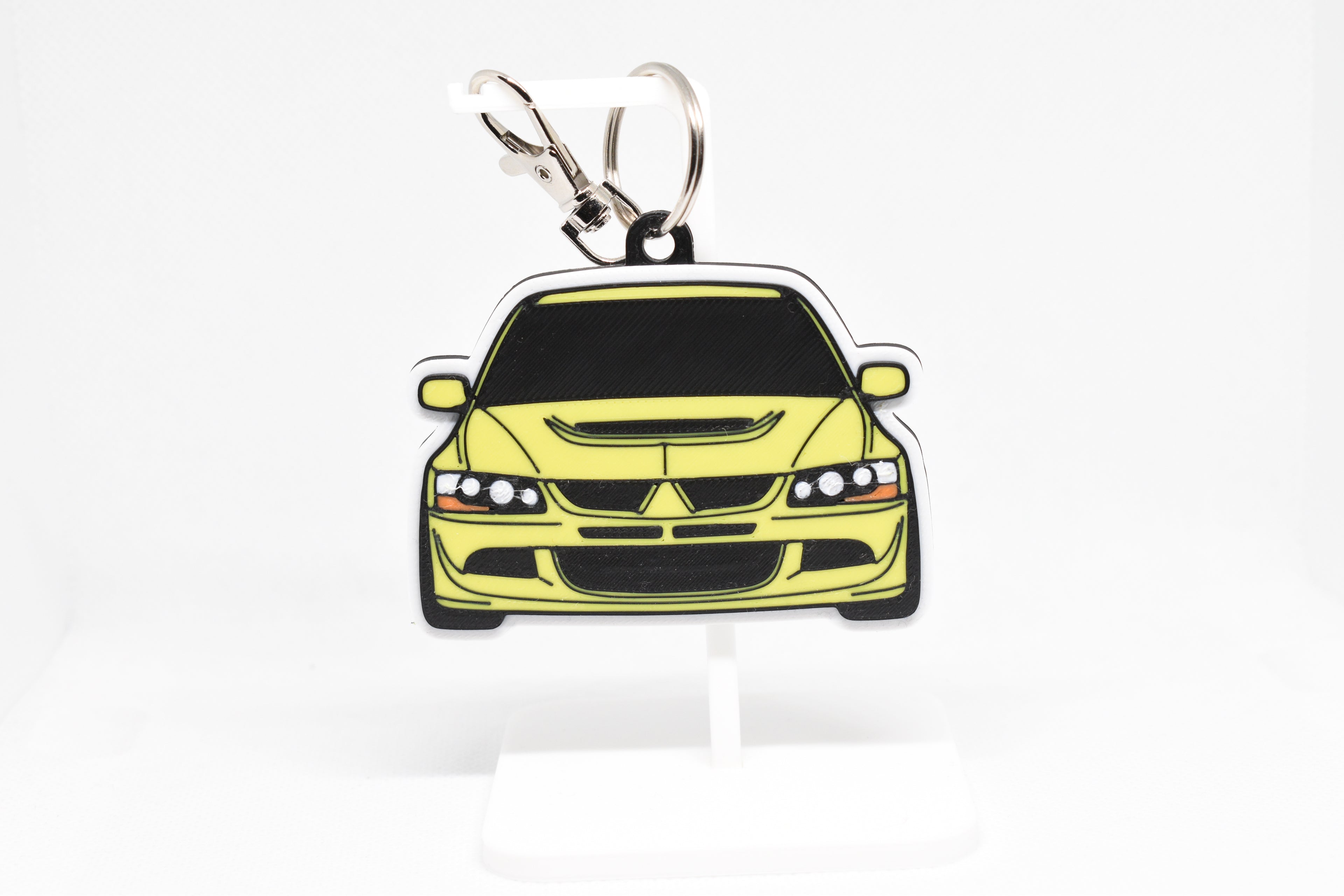 Pocket Motors Evo 8 keychain displayed on a white stand with metal ring and clip.