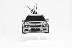 Pocket Motors Evo 9 keychain displayed on a white stand with metal ring and clip.
