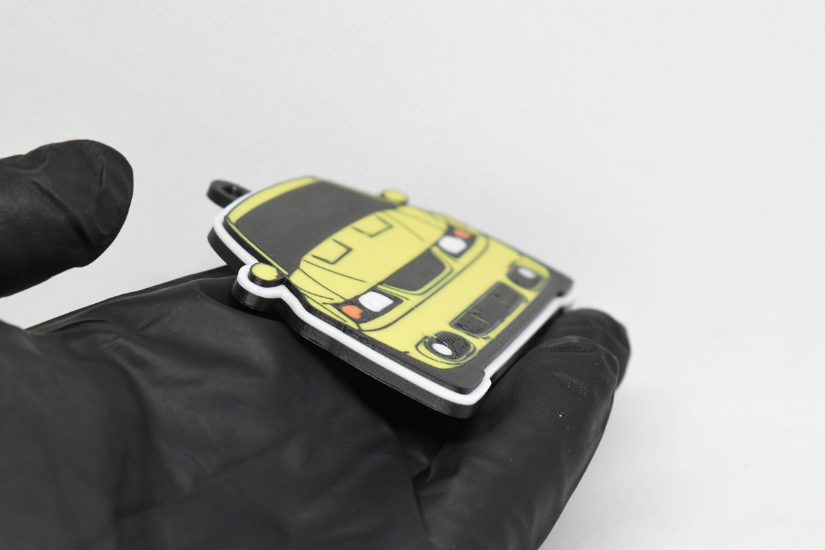 Side angle view showing 3D layered detail of yellow Ford Mustang Cobra SN95 facelift keychain by LayerPlay Pocket Motors