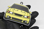 3D printed yellow Ford Mustang Cobra SN95 facelift keychain held in hand, front view detail by LayerPlay Pocket Motors