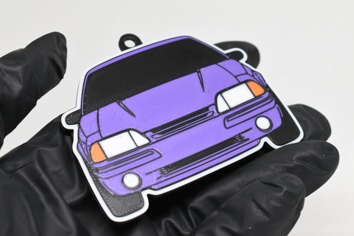 3D printed purple Ford Mustang Foxbody keychain held in hand, front view detail by LayerPlay Pocket Motors