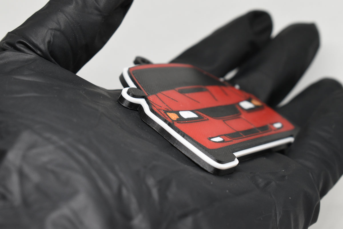 Side angle view showing 3D layered detail of red Ford Mustang GT SN95 facelift keychain by LayerPlay Pocket Motors