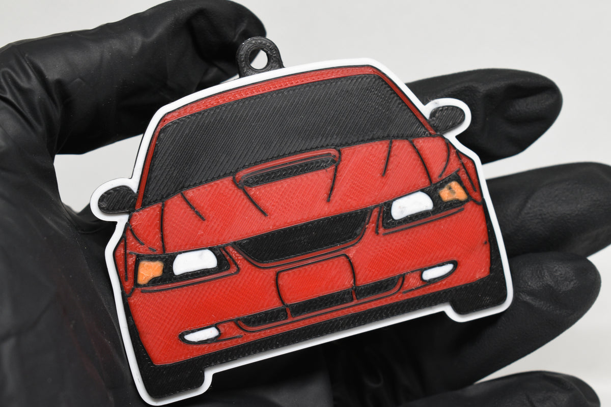 3D printed red Ford Mustang GT SN95 facelift keychain held in hand, front view detail by LayerPlay Pocket Motors