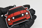3D printed red Ford Mustang S197 GT keychain held in hand, front view detail by LayerPlay Pocket Motors