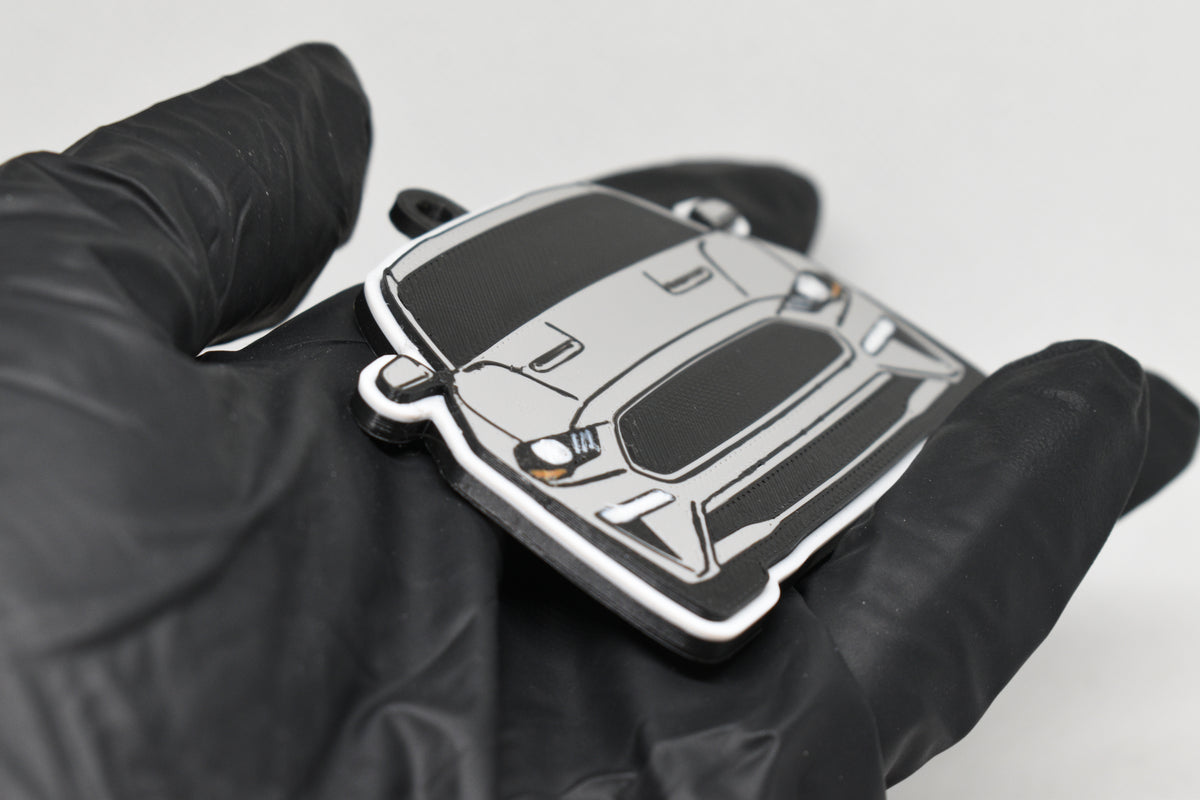 Side angle view showing 3D layered detail of light gray Ford Mustang S550 facelift keychain by LayerPlay Pocket Motors