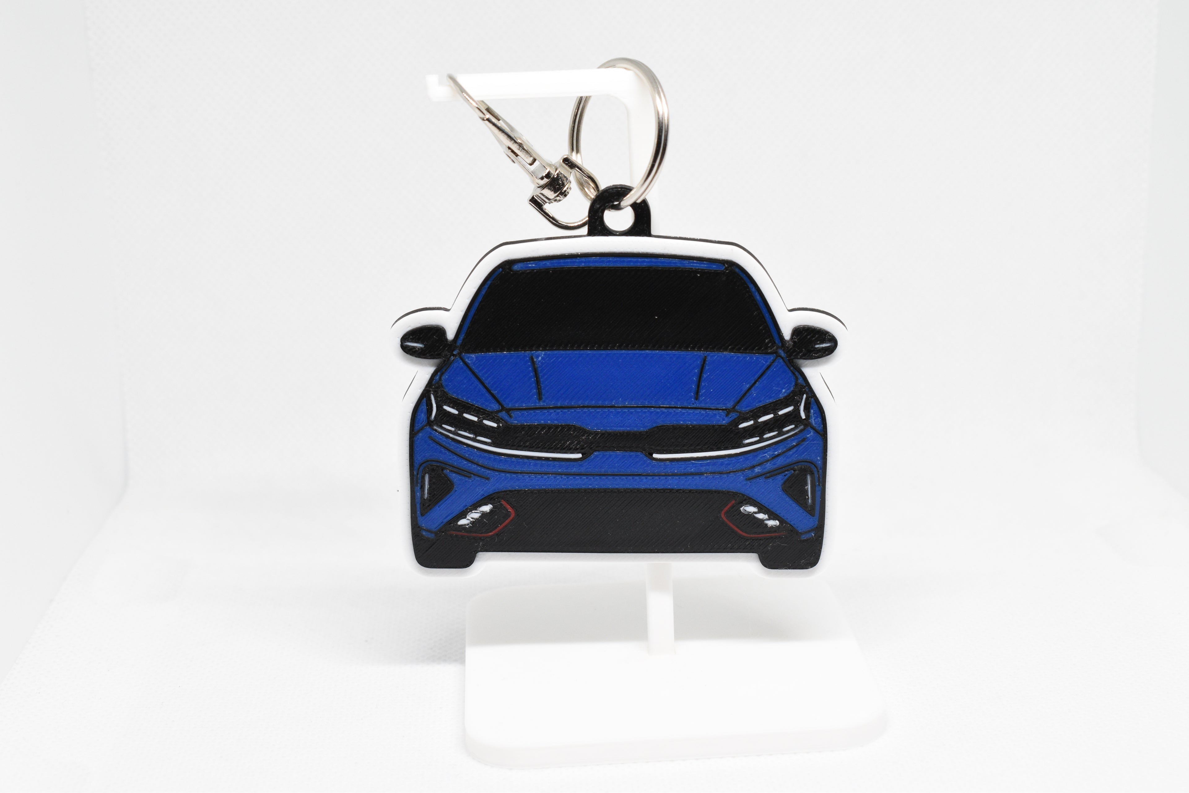 Pocket Motors Forte GT keychain displayed on a white stand with metal ring and clip.