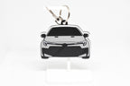 Pocket Motors GR Corolla facelift keychain displayed on a white stand with metal ring and clip.