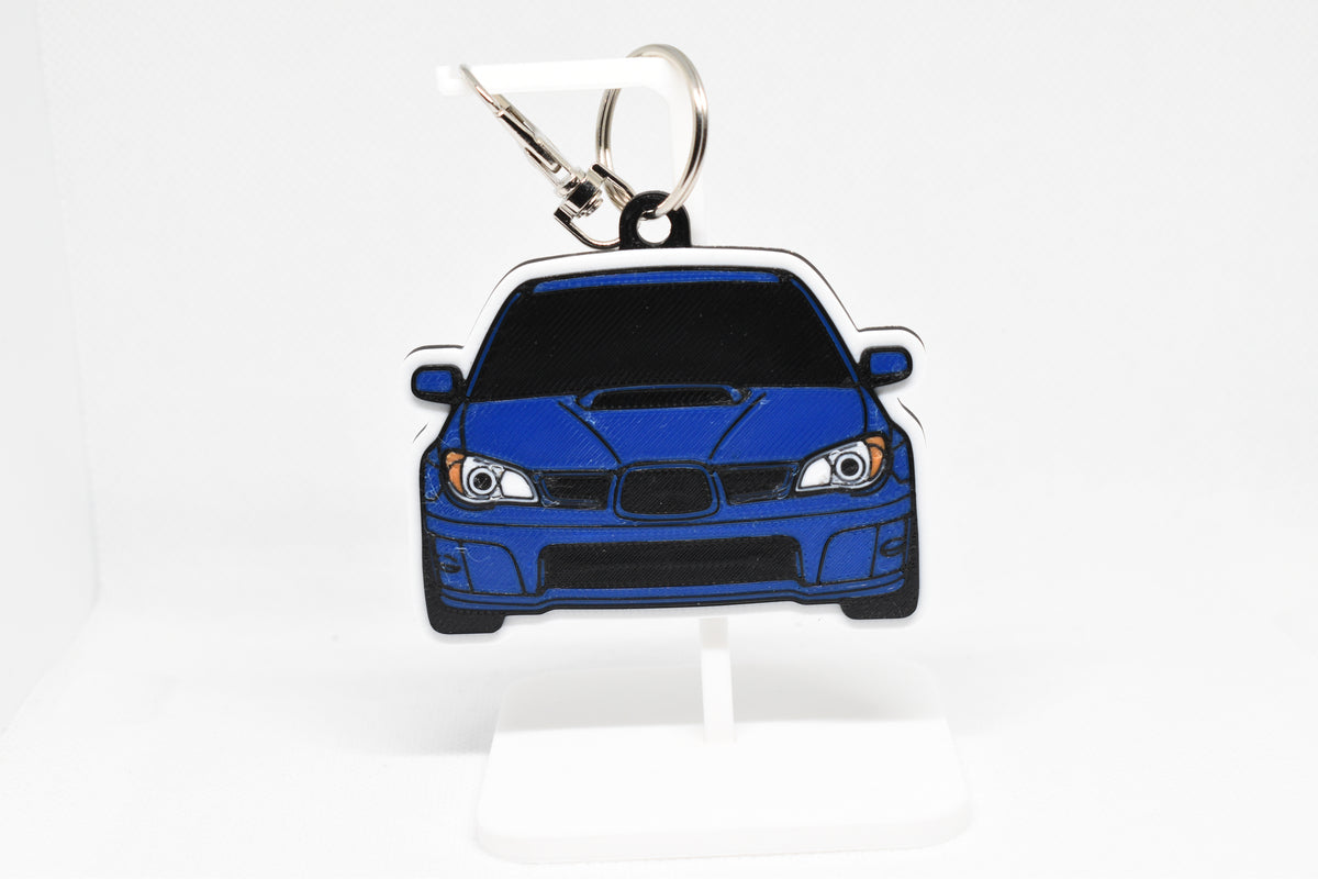 Pocket Motors Hawkeye Subaru WRX STI keychain displayed on a white stand with metal ring and clip.