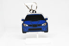 Pocket Motors Hawkeye WRX STI keychain displayed on a white stand with metal ring and clip.
