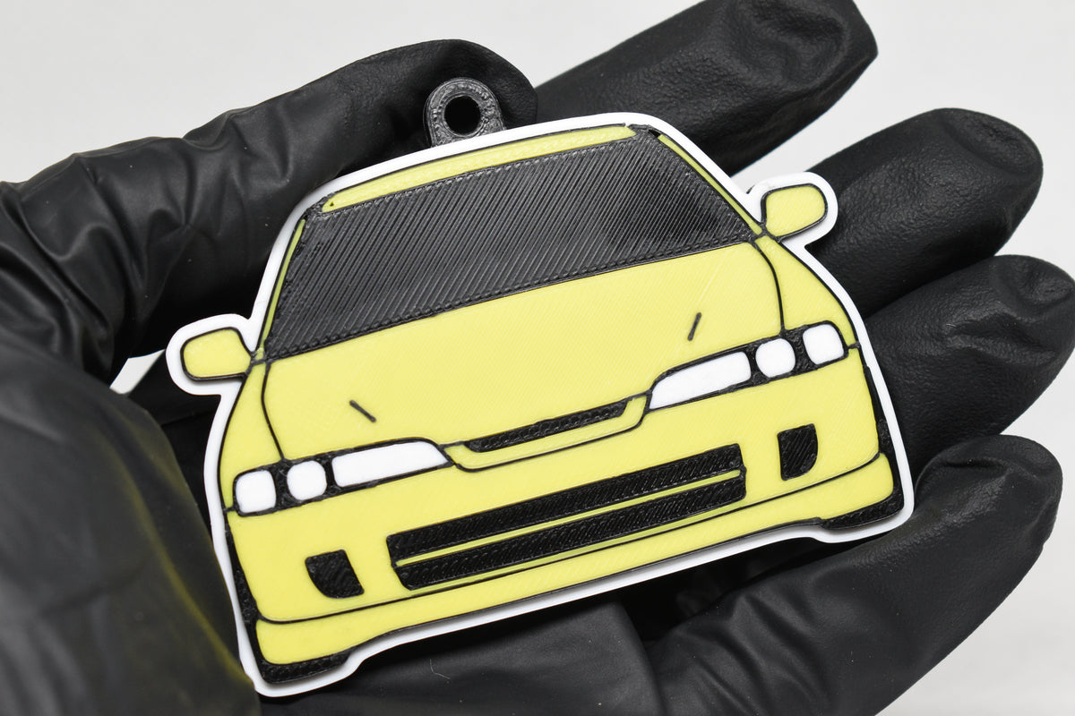 3D printed yellow JDM Honda Integra DC2 keychain held in hand, front view detail by LayerPlay Pocket Motors