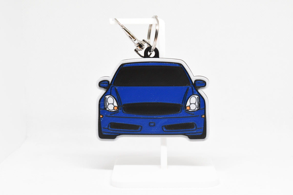 Pocket Motors G35 Coupe keychain displayed on a white stand with metal ring and clip.