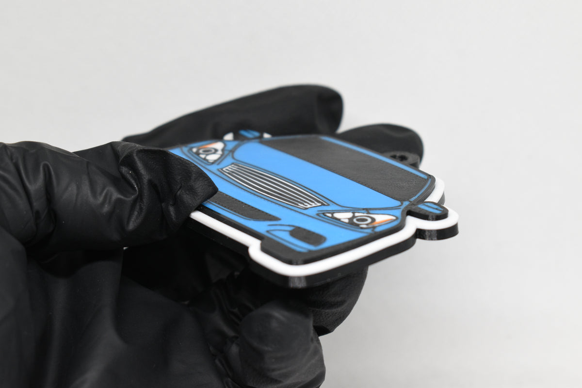 Side angle view showing 3D layered detail of light blue Infiniti G37 Coupe keychain by LayerPlay Pocket Motors