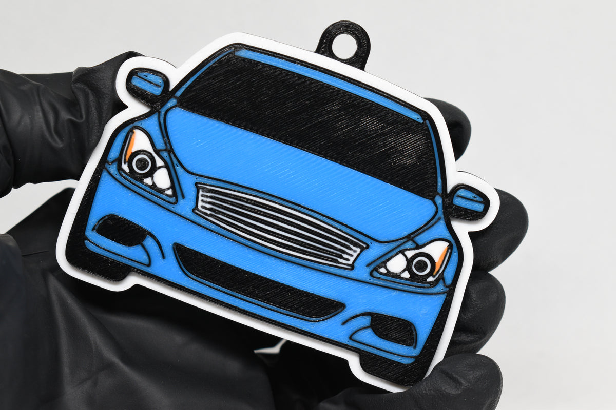 3D printed light blue Infiniti G37 Coupe keychain held in hand, front view detail by LayerPlay Pocket Motors
