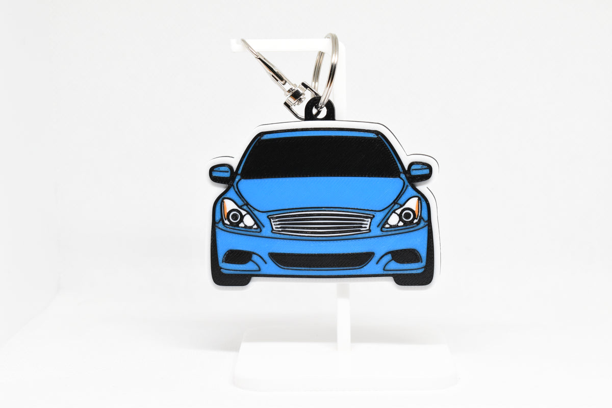 Pocket Motors infiniti G37 Coupe keychain displayed on a white stand with metal ring and clip.