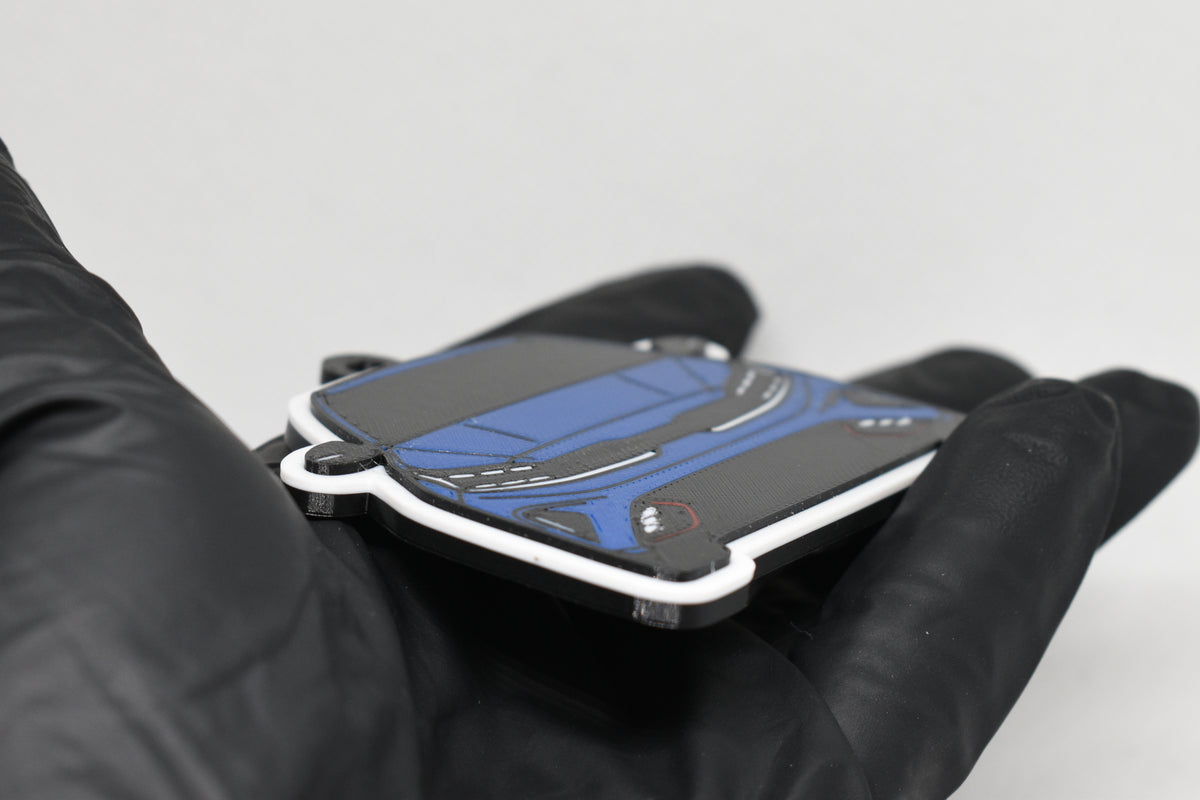 Side angle view showing 3D layered detail of blue Kia Forte GT keychain by LayerPlay Pocket Motors