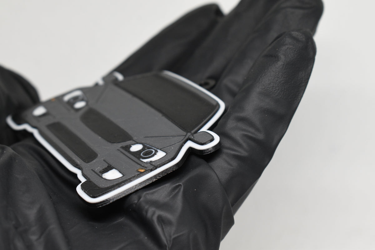 Side angle view showing 3D layered detail of space gray and black Lexus IS300 SXE10 keychain by LayerPlay Pocket Motors