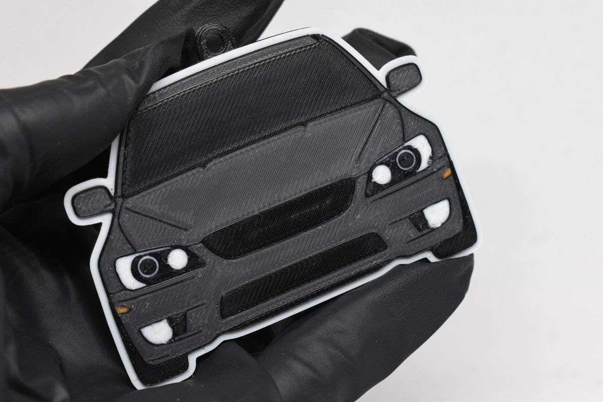 3D printed space gray and black Lexus IS300 SXE10 keychain held in hand, front view detail by LayerPlay Pocket Motors