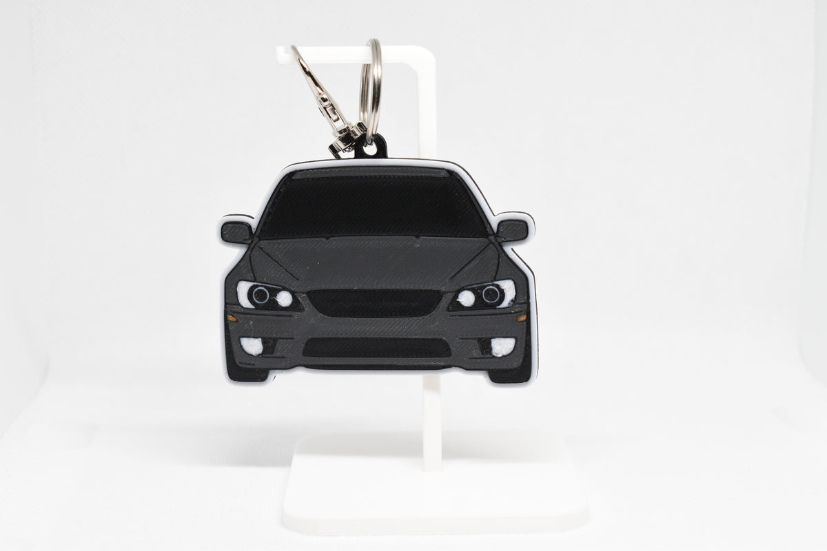 Pocket Motors Lexus IS300 SXE10 keychain displayed on a white stand with metal ring and clip.