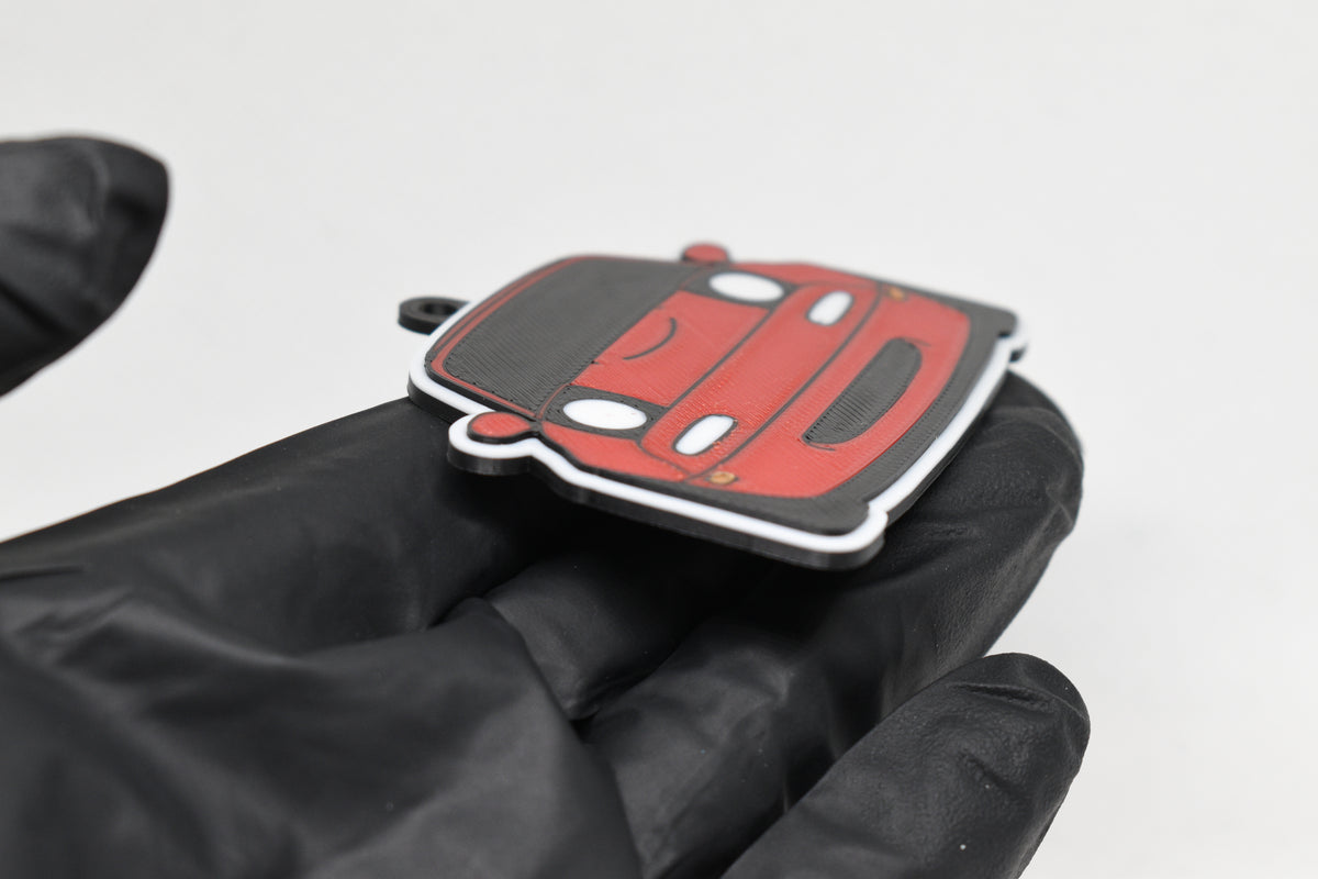 Side angle view showing 3D layered detail of red Mazda Miata NA keychain by LayerPlay Pocket Motors