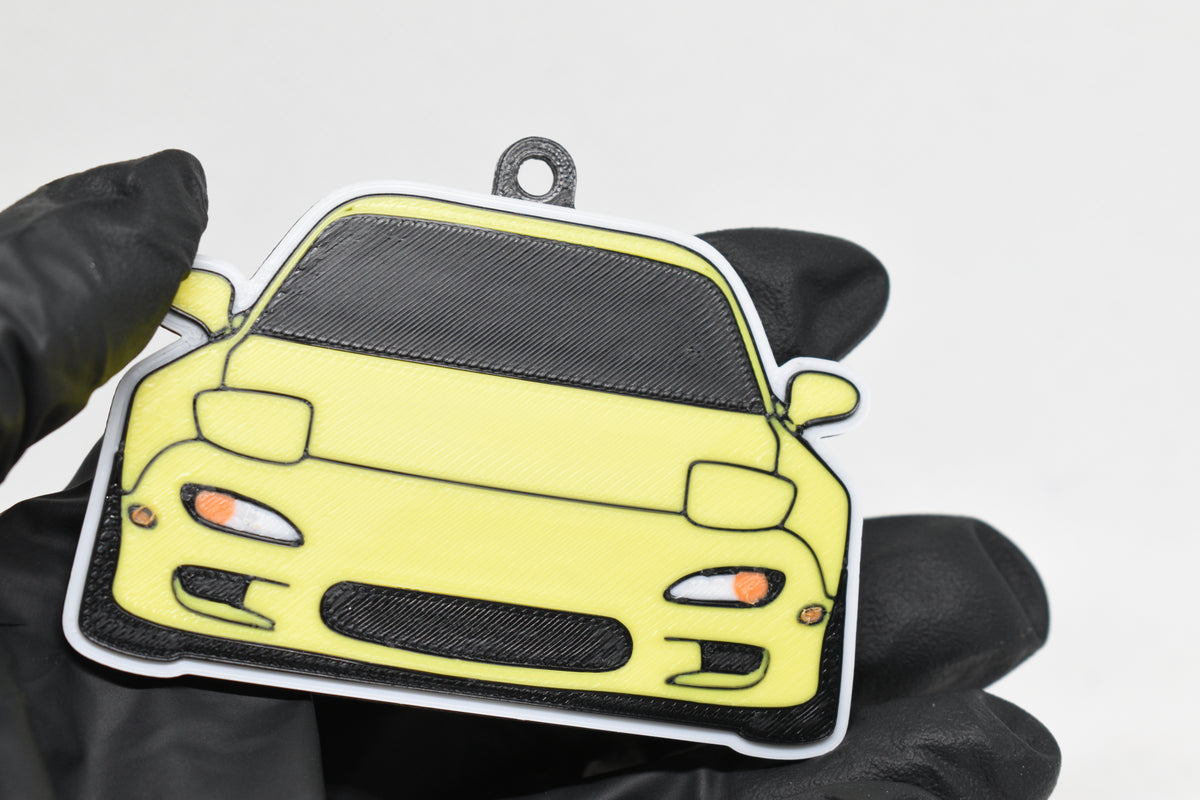 3D printed yellow Mazda RX-7 FD keychain held in hand, front view detail by LayerPlay Pocket Motors