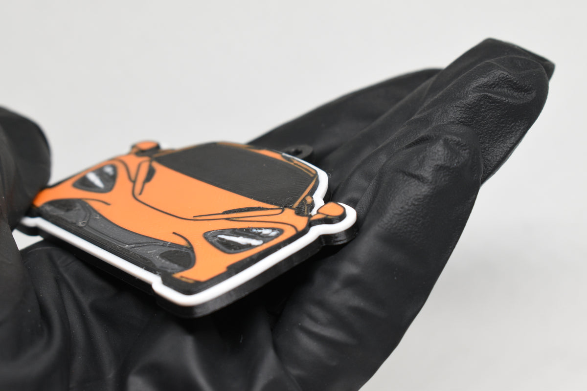 Side angle view showing 3D layered detail of orange McLaren 720S keychain by LayerPlay Pocket Motors