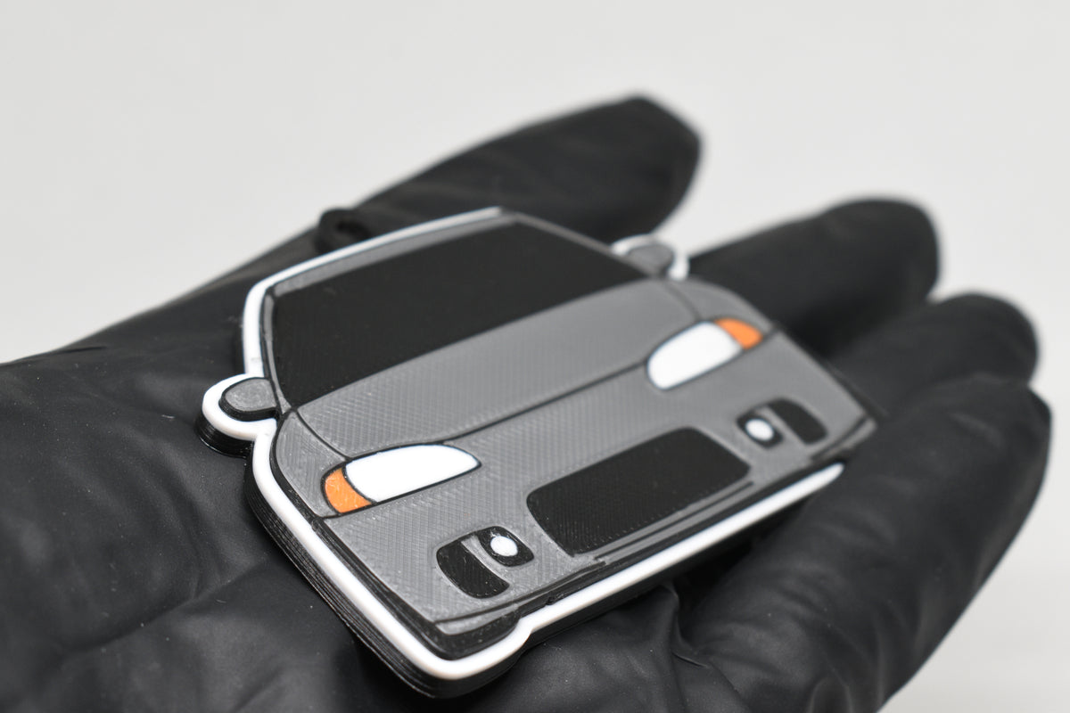 Side angle view showing 3D layered detail of light gray Mitsubishi Eclipse 2nd Gen keychain by LayerPlay Pocket Motors