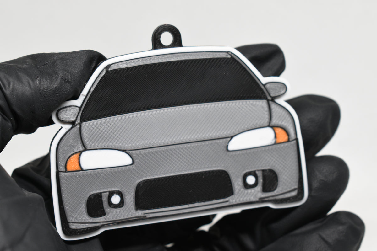 3D printed light gray Mitsubishi Eclipse 2nd Gen keychain held in hand, front view detail by LayerPlay Pocket Motors